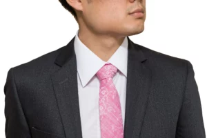 man wearing a black suit with a pink tie
